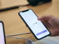 Dłoń trzyma smartfon, na ekranie którego wyświetla się komunikat "Face ID". Wygląda na to, że Face ID nie działa.