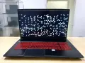 Laptop z artefaktami na ekranie, wskazującymi na problemy z kartą graficzną. Klawiatura podświetlona na czerwono.