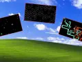 Trzy czarne prostokąty unoszą się nad zielonym wzgórzem, przypominając wygaszacz ekranu Windows 11. Jeden zawiera kolorowe bańki, drugi ikony, a trzeci abstrakcyjne, kolorowe rury.