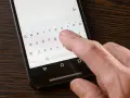 Palec naciska klawisz "Polski" na klawiaturze telefonu, aby włączyć polskie znaki w SMS.