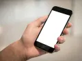 Dłoń trzyma smartfon z pustym ekranem. Cisza, brak id dzwoniącego.
