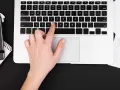Dłoń naciska klawisz "C" na klawiaturze laptopa, co może być przyczyną, dlaczego nie działa klawiatura w laptopie.