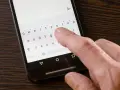 Palec naciska klawisz "Polski" na klawiaturze telefonu, aby ustawić polskie znaki w SMS.
