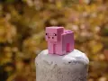 Różowa świnka z klocków Minecraft na białym postumencie. Może to być inspiracja do najlepszych modów do Minecraft, które dodają nowe zwierzęta.