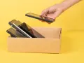 Ręka wkłada do kartonu kilka telefonów. Zastanawiam się, jaki mam model telefonu, bo wszystkie wyglądają podobnie.