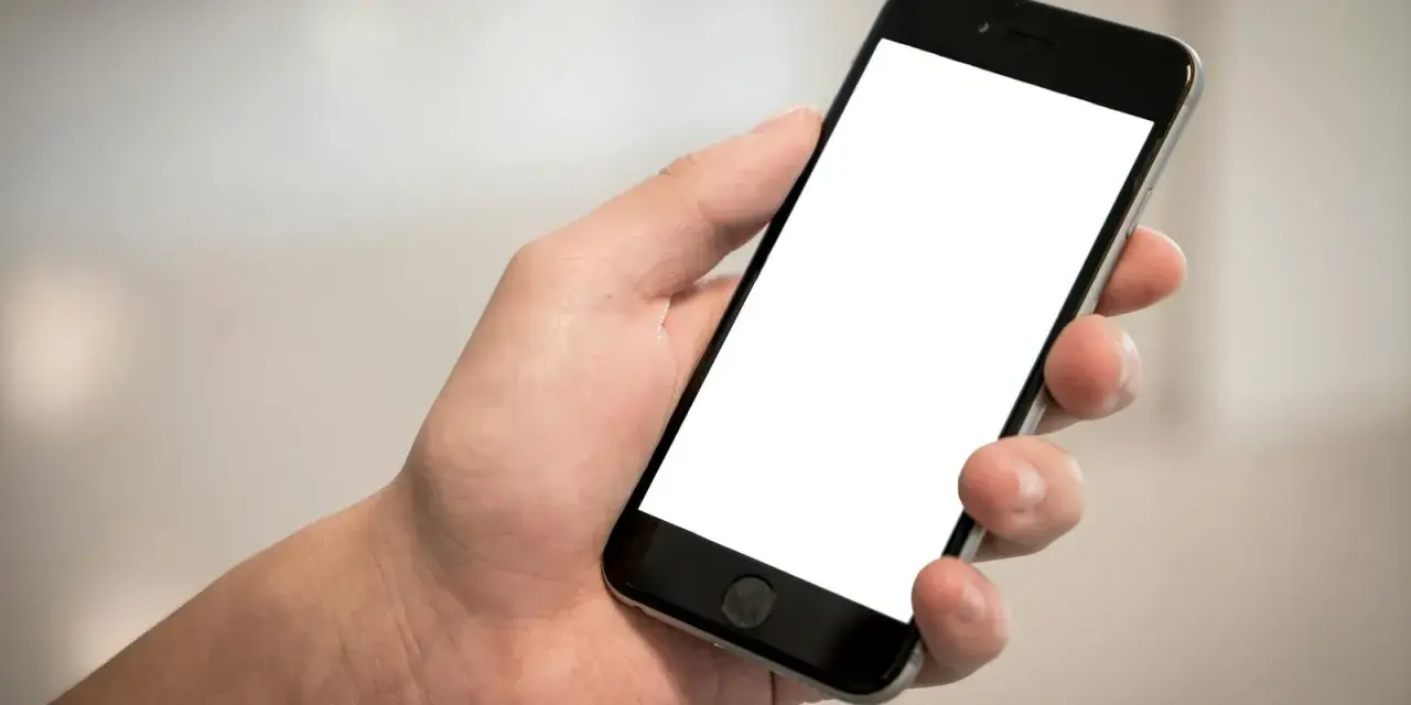 Dłoń trzyma smartfon z pustym ekranem. Cisza, brak id dzwoniącego.