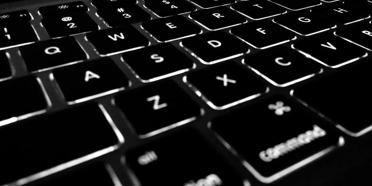 Podświetlane klawisze laptopa, w tym klawisze funkcyjne F1-F12, litery i symbole.