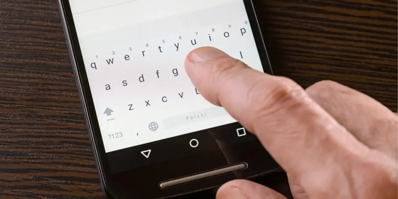 Palec naciska klawisz "Polski" na klawiaturze telefonu, aby ustawić polskie znaki w SMS.
