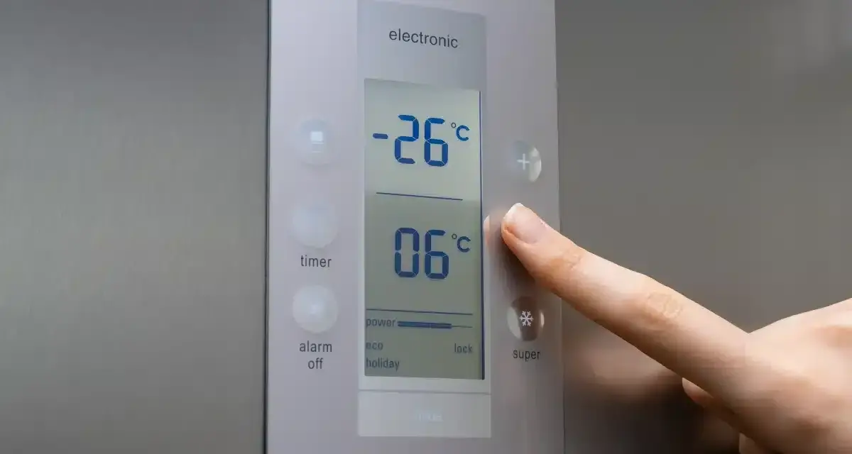 Palec naciska przycisk "super" na panelu lodówki no frost. Wyświetlacz pokazuje -26°C i 06°C.