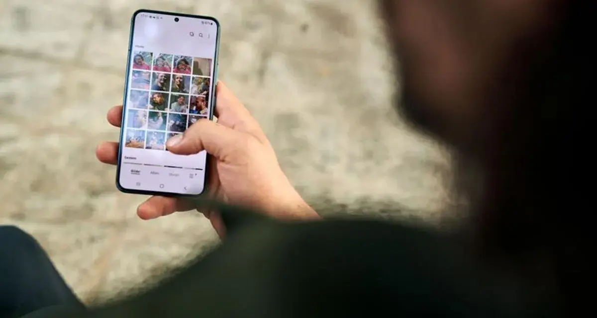 Osoba przegląda zdjęcia na telefonie, zastanawiając się, jak usunąć aplikacje z telefonu, by zwolnić miejsce.