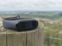 Czarny Mi Band 4 na drewnianym słupku, idealny do śledzenia aktywności. To najlepsza aplikacja do Mi Band 4 dla aktywnych osób.