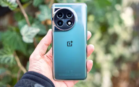 Dłoń trzyma zielony telefon z okrągłym aparatem Hasselblad.