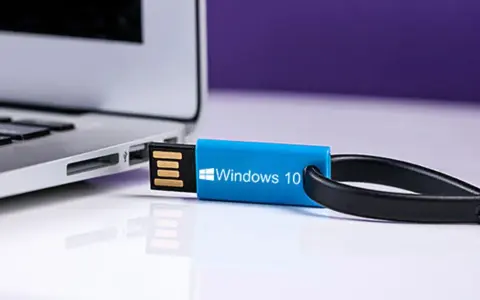 Niebieski pendrive z napisem "Windows 10" podłączony do laptopa. Idealny do nauki, jak zrobic format komputera win 10.