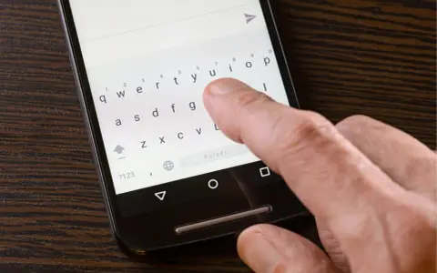 Palec naciska klawisz "Polski" na klawiaturze telefonu, aby włączyć polskie znaki w SMS.