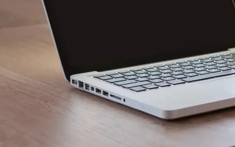 Czekam na inspirację, gdy czarny ekran w laptopie odbija światło.