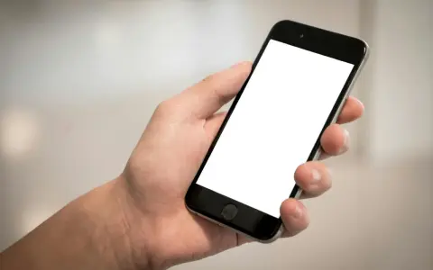 Dłoń trzyma smartfon z pustym ekranem. Cisza, brak id dzwoniącego.