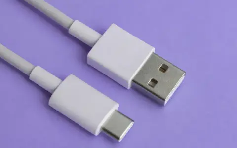 Biały kabel z wtyczkami USB-A i USB typu C na fioletowym tle.