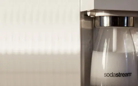 Zbliżenie na butelkę SodaStream z bąbelkami, gotową do wymiany butli.