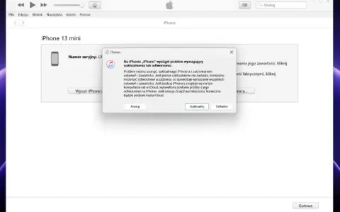 Komunikat w iTunes informuje o problemie z iPhone'em 13 mini, sugerując uaktualnienie lub odtworzenie, co może pomóc jak usunąć blokadę ekranu.