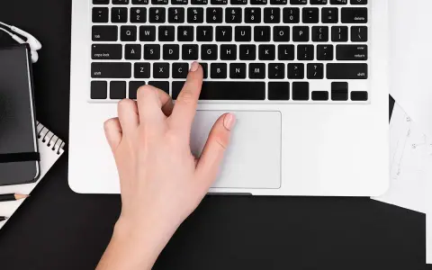 Dłoń naciska klawisz "C" na klawiaturze laptopa, co może być przyczyną, dlaczego nie działa klawiatura w laptopie.
