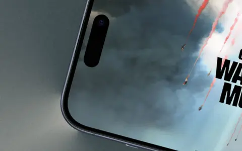 Telefon z ekranem gry Call of Duty Warzone Mobile. Widać spadające postacie z czerwonymi smugami dymu na tle burzowych chmur.