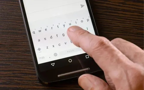 Palec naciska klawisz "Polski" na klawiaturze telefonu, aby ustawić polskie znaki w SMS.