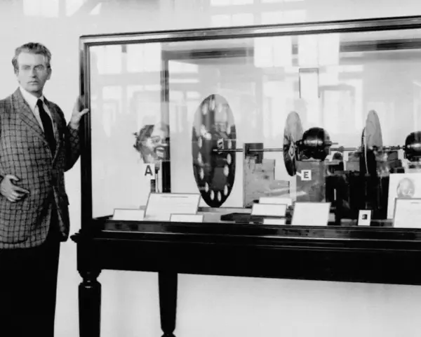 John Logie Baird prezentuje swój wynalazek – pierwszy telewizor na świecie. W gablocie widać dyski Nipkow i silniki.