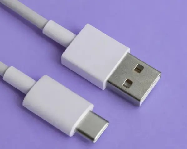 Biały kabel z wtyczkami USB-A i USB typu C na fioletowym tle.