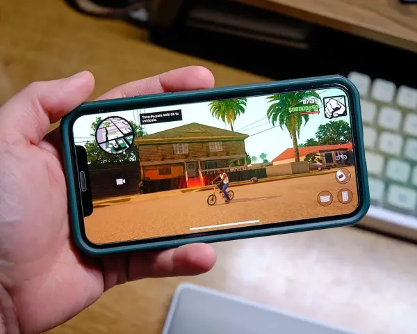 Ręka trzyma smartfon z grą GTA: San Andreas. To świetny przykład darmowe gry na komórkę, które pozwalają na wirtualną rozrywkę.