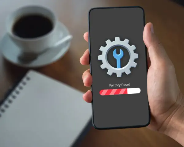 Telefon z ikoną narzędzi i paskiem postępu "Factory Reset". To może pomóc, gdy chcesz naprawić dotyk w telefonie.