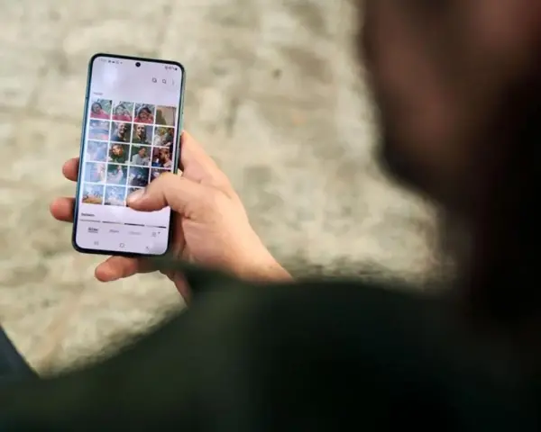 Osoba przegląda zdjęcia na telefonie, zastanawiając się, jak usunąć aplikacje z telefonu, by zwolnić miejsce.