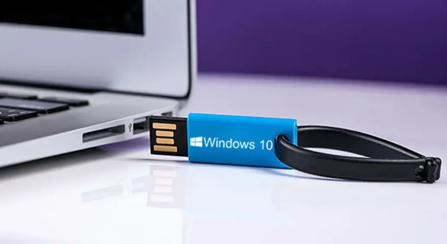 Niebieski pendrive z napisem "Windows 10" podłączony do laptopa. Idealny do nauki, jak zrobic format komputera win 10.