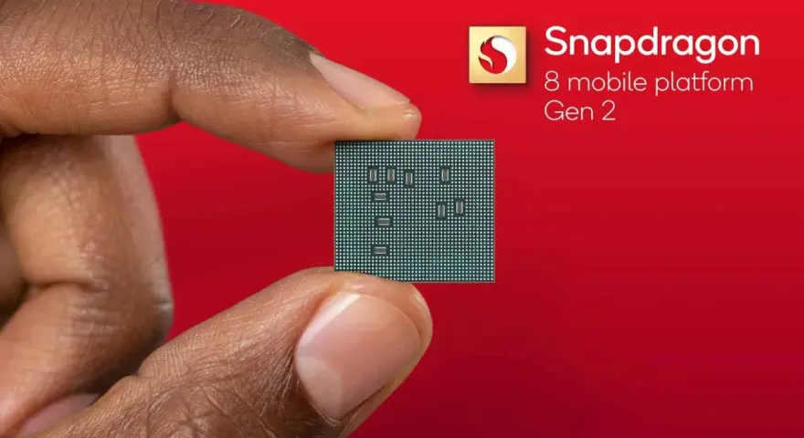 Palec i kciuk trzymają niewielki procesor. Obok widnieje logo Snapdragon 8 mobile platform Gen 2.