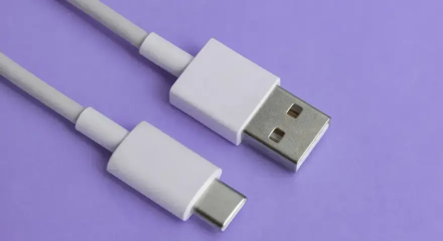 Biały kabel z wtyczkami USB-A i USB typu C na fioletowym tle.