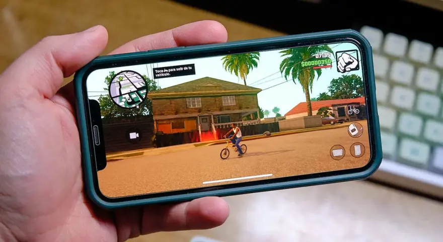 Ręka trzyma smartfon z grą GTA: San Andreas. To świetny przykład darmowe gry na komórkę, które pozwalają na wirtualną rozrywkę.