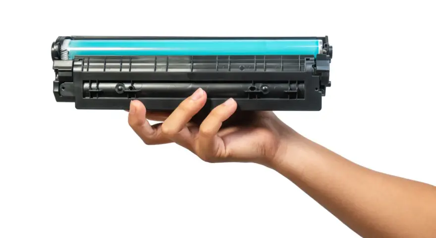 Dłoń trzymająca toner do drukarki HP. Dowiedz się, jak wymienić tusz w drukarce HP, aby cieszyć się wydrukami.