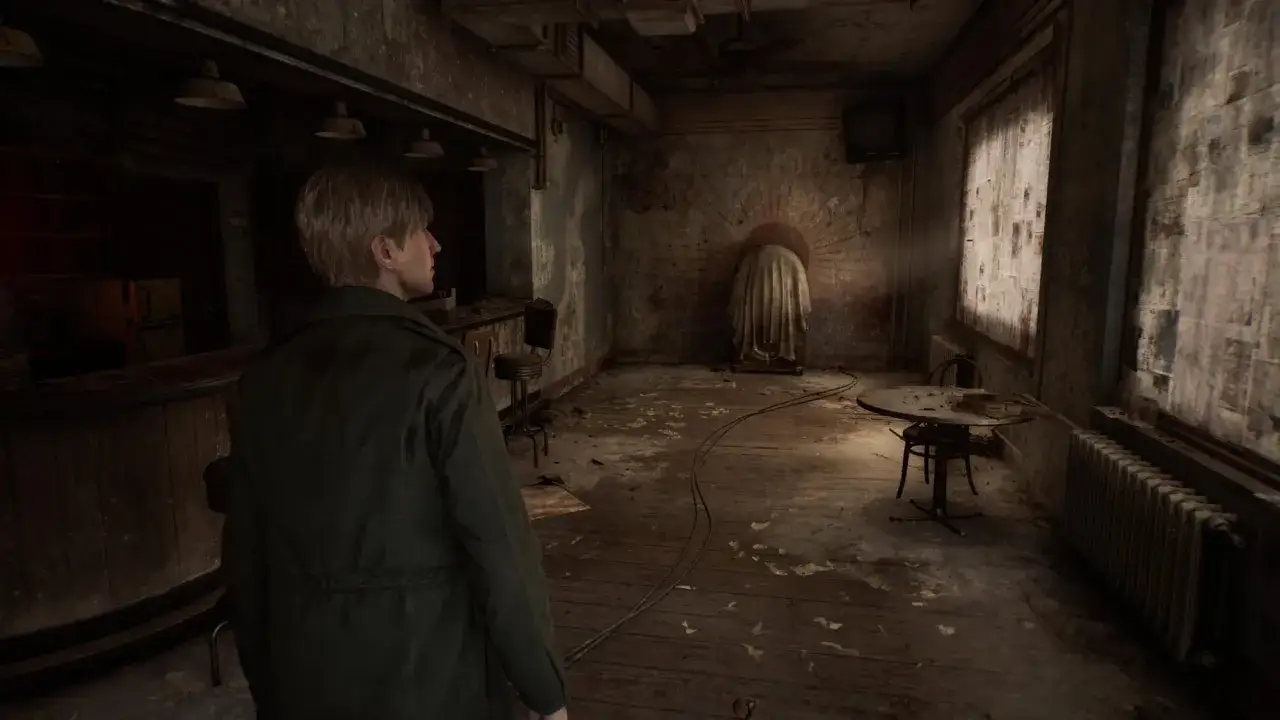 James Sunderland w opuszczonym pokoju, przygotowując się na spotkanie z potworami w Silent Hill remake.