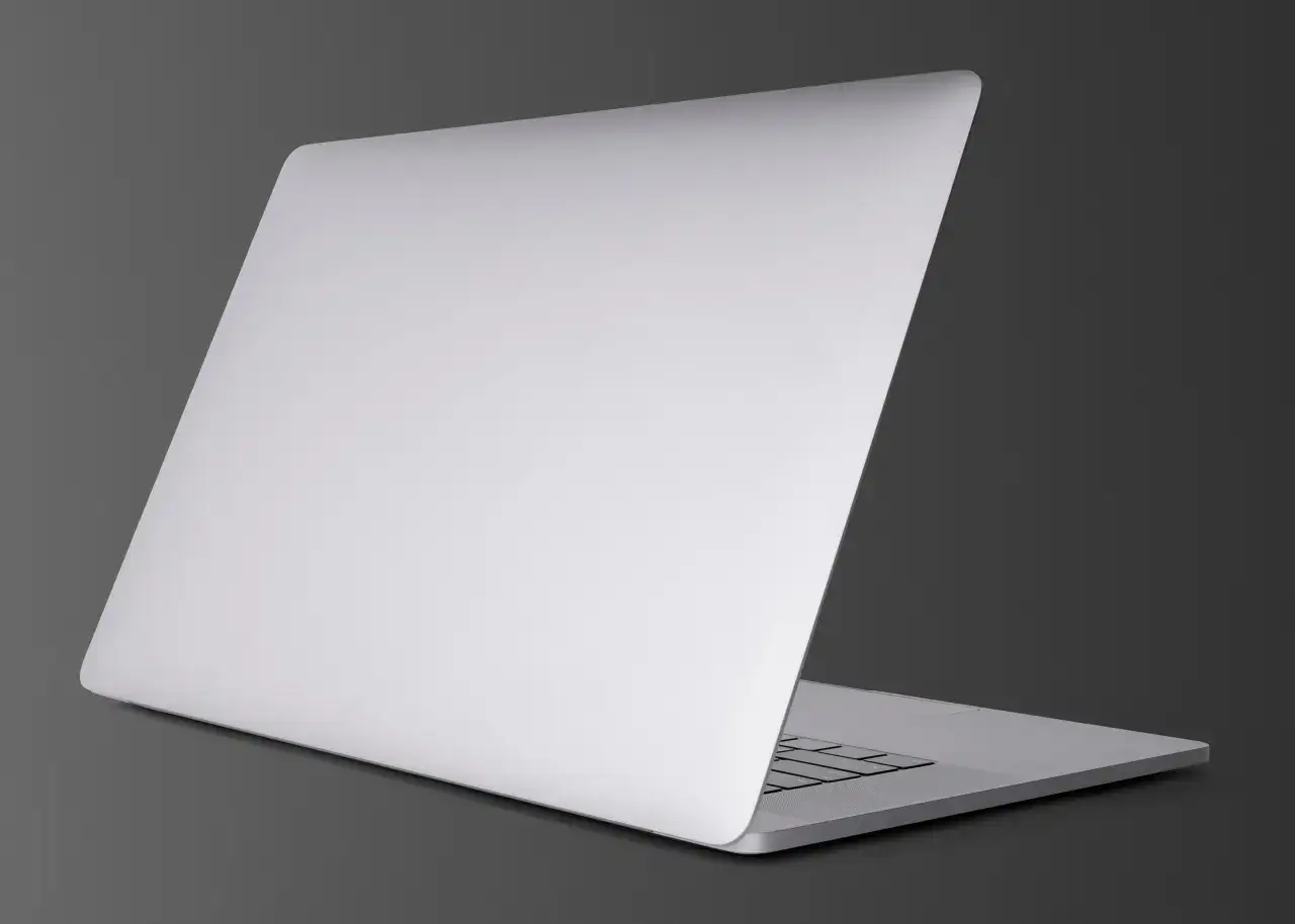 Srebrny, otwarty laptop, kt&oacute;ry wygląda jak nowy MacBook, gotowy do pracy.